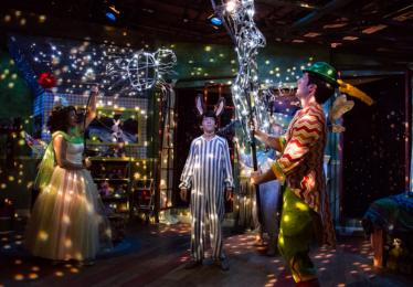 actors on dark stage with fairy lights